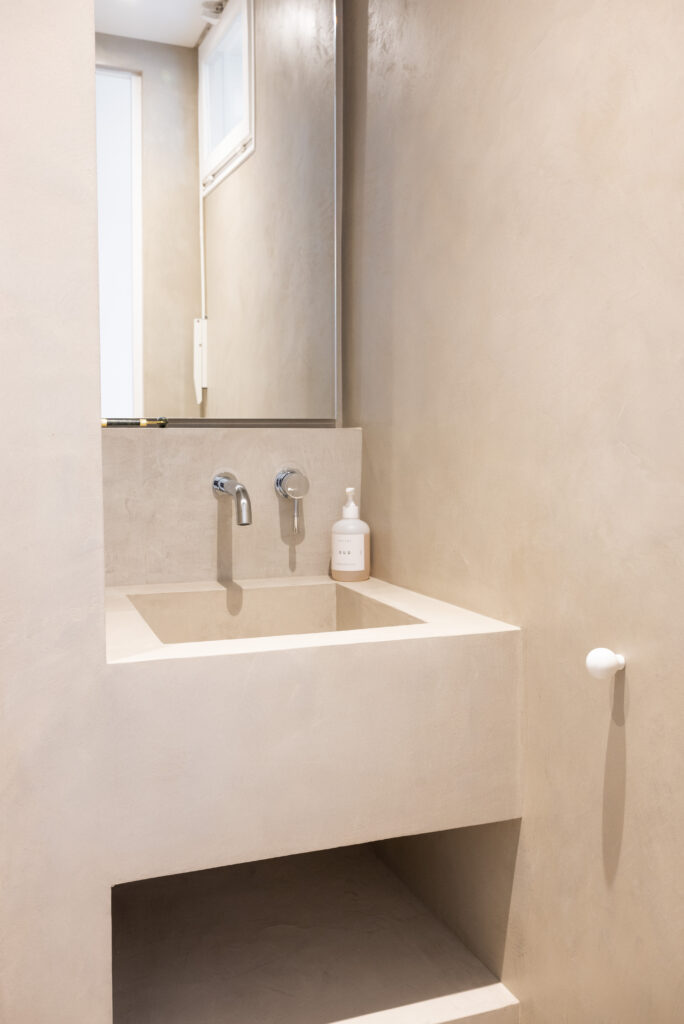 Aménager un bien d'exception : une petite salle de bain en béton ciré gris clair